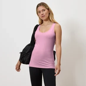 Nő rózsaszín trikóban és fekete leggingsben, fekete táskával a vállán.