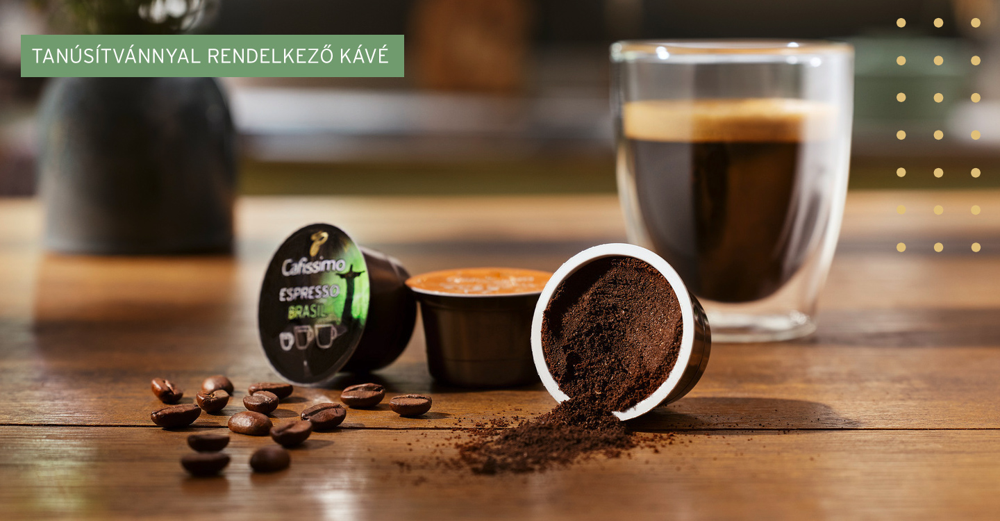 Glas Kaffee steht mit zwei Cafissimo Kapsen auf einem Tisch